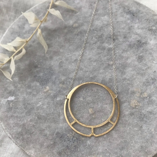 brass circle and silver necklace