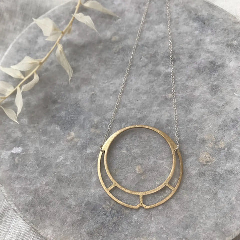 brass circle and silver necklace